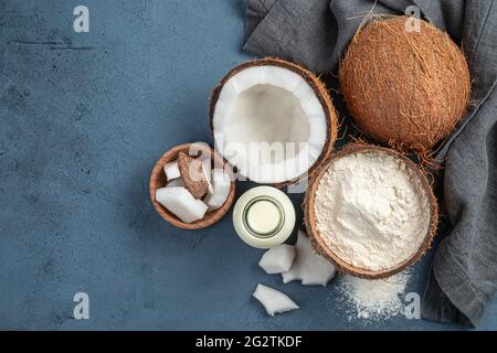 Coconut milk, flour and coconuts on a dark background. Top view, space for copying. Stock Photo