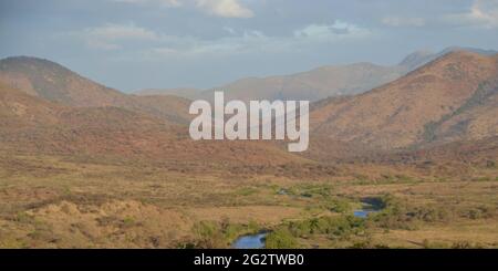 Scenic wilderness view on the South African highveld near Barberton/Elukwatini with the Mountain Kingdom of Eswatini in the background with a river Stock Photo