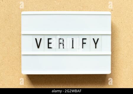 Lightbox with word verify on wood background Stock Photo
