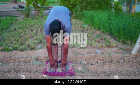 Morning sunrise, Namaste Lotus pose. Meditation and Relax. Indian man doing yoga on world yoga day. Stock Photo