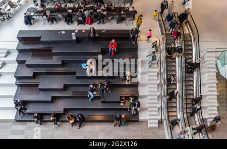 People on the steps and escalators in the Groninger Forum in The Netherlands Stock Photo
