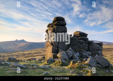 The photograph features rocks on Hound Tor in the Dartmoor National Park in Devon captured shortly after sunrise with Haytor in the distance. Stock Photo