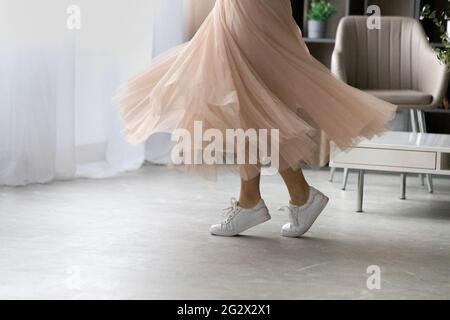 Feet of young lady dancing on tiptoes at living room Stock Photo