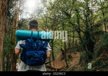 young man with backpack doing trekking or hiking Stock Photo