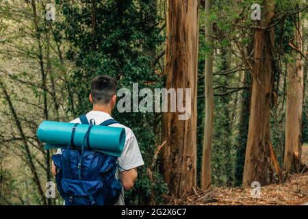 young man with backpack doing trekking or hiking Stock Photo