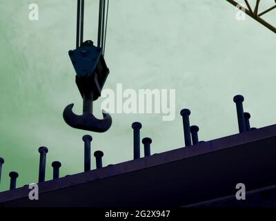 Heavy iron nails industrial view with blur crane hook on sky background Stock Photo