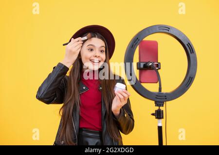 happy teen girl blogger use selfie led lamp and smartphone on tripod, blog. Stock Photo