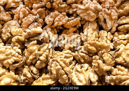 Walnuts with (filling the picture). Background of fresh broken walnuts. Top view blur textures soft focus. Stock Photo