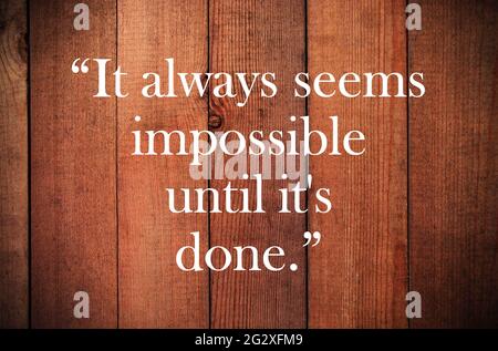 Inspirational quote, motivation. Typography on wooden background. It always seems impossible until its done. invitation, greeting card printing. Stock Photo