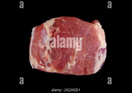 Overhead view of raw piece of pork isolated on black background. Piece of fresh boneless pork, neck part or collar. Food, grill and cooking concept. Stock Photo