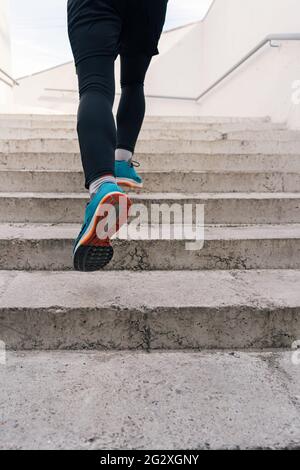 Young man legs running upstairs on city stairs. Fitness, sport, people, exercising and lifestyle concept Stock Photo