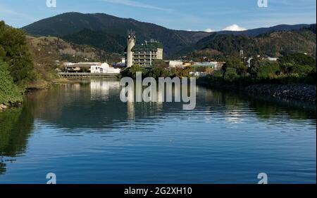 The Civic House clock tower building reflected in the Matai River, Nelson City, New Zealand. Stock Photo