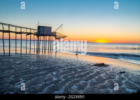 Gironde estuary with wooden fishing hut at sunset on beach at low tide in Charente Maritime, France near La Rochelle on west Atlantic coast Stock Photo