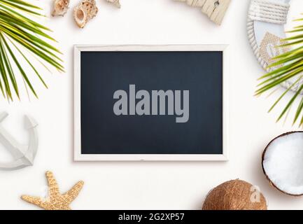 Empty chalkboard surrounded by summer, beach objects. Travel presentation, top view, flat lay composition Stock Photo