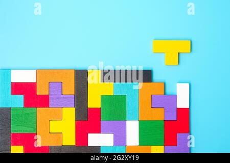 colorful wood puzzle pieces on blue background, geometric shape block. Concepts of logical thinking, Conundrum, solutions, rational, strategy, world l Stock Photo