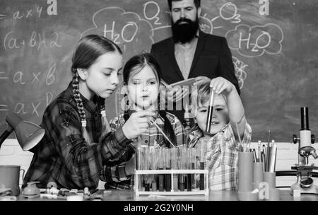 children making science experiments. Education. chemistry lab. happy children and teacher. back to school. doing experiments with liquids in chemistry Stock Photo