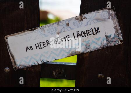 From here on, please smile, signboard on Garden Stock Photo