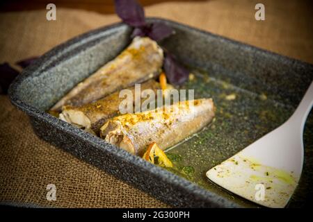 fish baked in the oven with spices, spices on a baking sheet Stock Photo