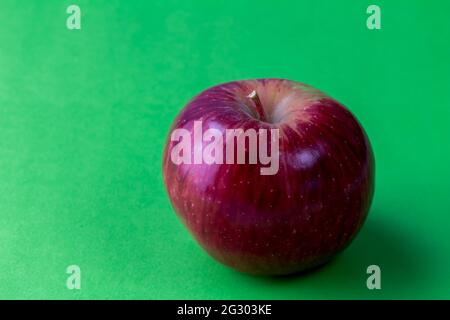 Red apple on green background with shadow and space for text Stock Photo