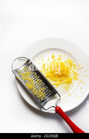 Grater and lemon zest isolated on white background. Directly above. Copy space. Stock Photo
