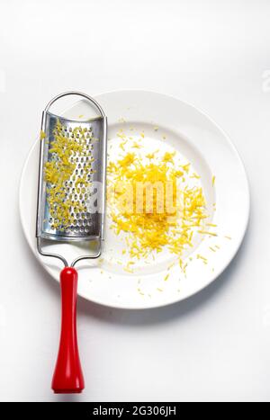 Grater and lemon zest isolated on white background. Directly above. Copy space. Stock Photo
