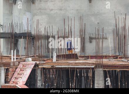 A construction worker working on the roof supported by bars Stock Photo