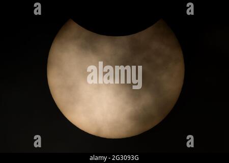 UK Weather: Partial solar eclipse seen from Greenwich Park reaches its totality with the moon hiding nearly a third of the sun’s area. London, UK. Stock Photo