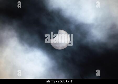 UK Weather: Partial solar eclipse seen from Greenwich Park reaches its totality with the moon hiding nearly a third of the sun’s area. London, UK. Stock Photo