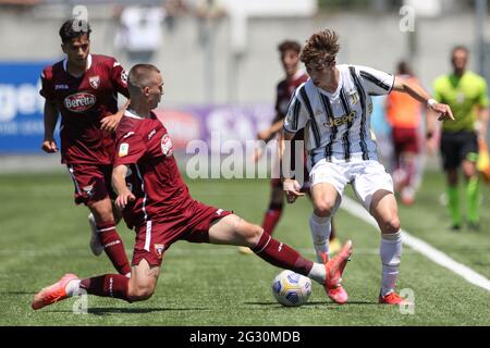 Volpiano, Italy, 13th June 2021. Albin Kryeziu of Torino FC slides in to challenge Fabio Miretti of Juventus during the Primavera 1 match at Centro Sportivo Bertoletti di Volpiano, Volpiano. Picture credit should read: Jonathan Moscrop / Sportimage Stock Photo