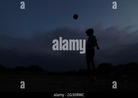 Chennai, Tamil Nadu, India. 13th June, 2021. As the dark clouds loom over the skies, kids seen playing football at a deserted ground in Chennai. Credit: Sri Loganathan/ZUMA Wire/Ģ����ý Live News Stock Photo