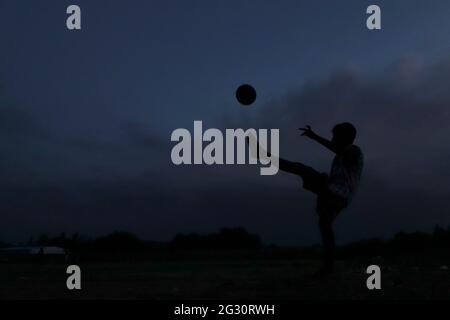 Chennai, Tamil Nadu, India. 13th June, 2021. As the dark clouds loom over the skies, kids seen playing football at a deserted ground in Chennai. Credit: Sri Loganathan/ZUMA Wire/Ģ����ý Live News Stock Photo