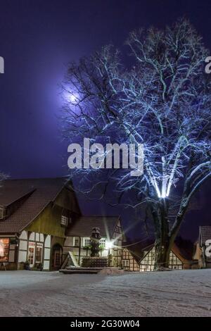 romantic nightscape at old german city with half-timbered houses and snow covered tree in moonlight, Tecklenburg, Germany Stock Photo