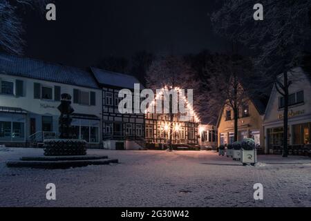 romantic nightscape at old german city with half-timbered houses and snow covered tree on market square, Tecklenburg, Germany Stock Photo