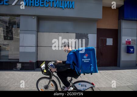 Moscow, Russia. 1st of June, 2021 The courier of the pizza delivery service 'Domino's Pizza' delivers the order to the customer in the center of Moscow, Russia Stock Photo