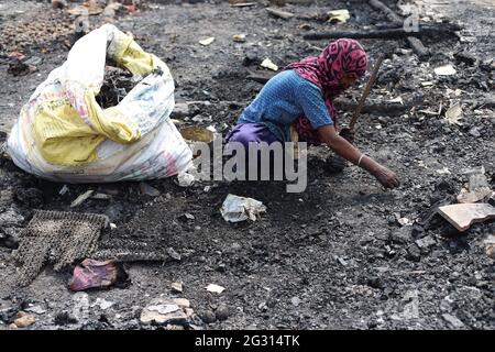 New Delhi, India. 13th June, 2021. A Rohingya refugee looks for her belongings amid the charred remains of their camp, during the aftermath.A fire incident broke out at the Rohingya refugee camp leaving over 50 shanties of Rohingya refugees gutted. The cause of the fire has not yet been established. Credit: SOPA Images Limited/Alamy Live News Stock Photo