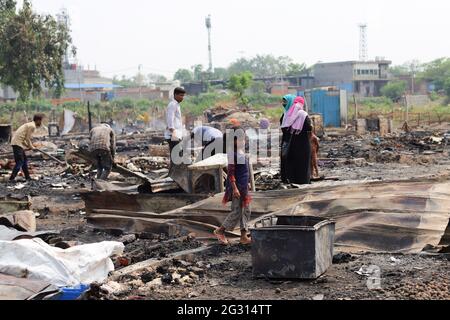 New Delhi, India. 13th June, 2021. A kid seen look around the charred remains of their camp, during the aftermath. A fire incident broke out at the Rohingya refugee camp leaving over 50 shanties of Rohingya refugees gutted. The cause of the fire has not yet been established. Credit: SOPA Images Limited/Alamy Live News Stock Photo