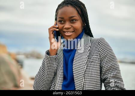 Young african american businesswoman smiling happy talking on the smartphone at the port. Stock Photo