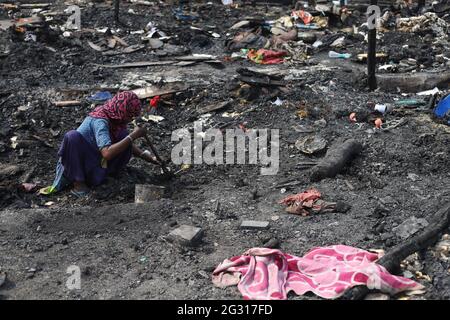 New Delhi, India. 13th June, 2021. A woman looks in the charred remains of their camp, during the aftermath.A fire incident broke out at the Rohingya refugee camp leaving over 50 shanties of Rohingya refugees gutted. The cause of the fire has not yet been established. (Photo by Amarjeet Kumar Singh/SOPA Imag/Sipa USA) Credit: Sipa USA/Alamy Live News Stock Photo