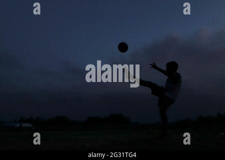 Chennai, Tamil Nadu, India. 13th June, 2021. As the dark clouds loom over the skies, kids seen playing football at a deserted ground in Chennai. Credit: Sri Loganathan/ZUMA Wire/Ģ����ý Live News Stock Photo
