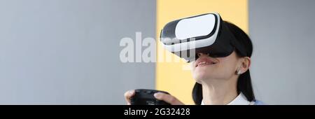 Young woman in virtual reality glasses holding joystick Stock Photo