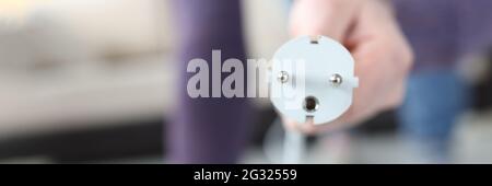 Male hand inserting plug into socket at home closeup Stock Photo