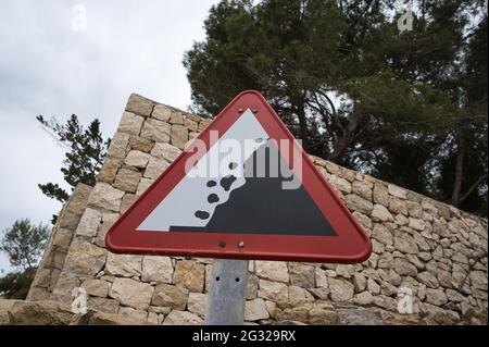cave-in danger sign with stones and trees behind. view Stock Photo