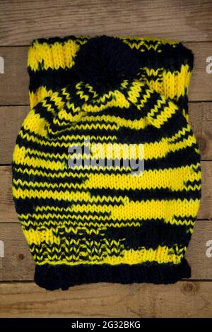 Handmade wool knitted winter hat and scarf isolated on old wood background Stock Photo