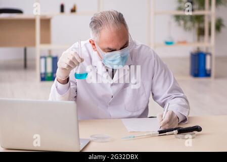Old chemist working in the lab during pandemic Stock Photo
