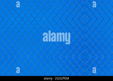 Seamlessly tileable texture of wire mesh on a blue sky. Stock Photo