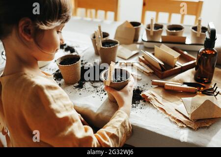 6 years old girl planting herbs at home Stock Photo