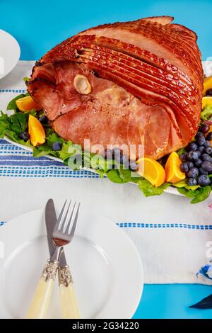 Spiral sliced hickory smoked ham with fresh orange and blueberries. Stock Photo