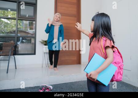 happy kid wave goodbye to mother before going to school Stock Photo