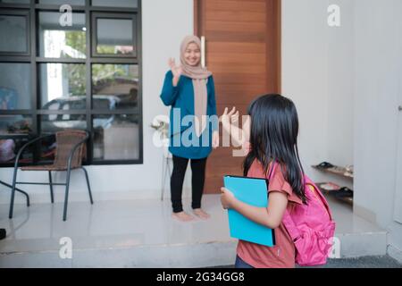 happy kid wave goodbye to mother before going to school Stock Photo