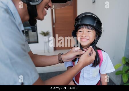 father taking his daughter to school by motorcycle in the morning Stock Photo
